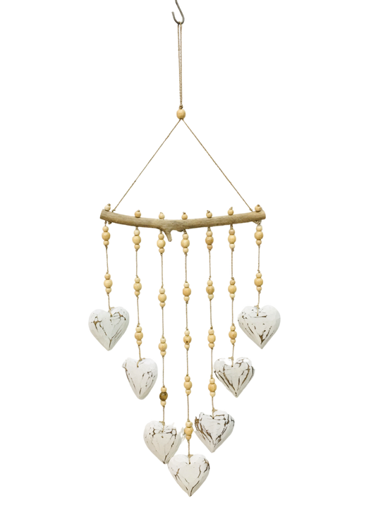 A hanging mobile with seven white love hearts and brown patterned carving on each heart. 